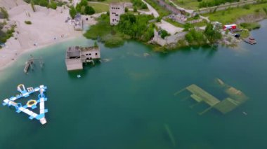 Abandoned quarry for extraction of limestone. Beautiful nature, attraction in Estonia. The summer season. Aerial Rummu quarry lake with underwater prison in the middle