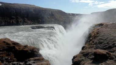 İzlanda 'daki Altın Daire' deki Gullfoss şelalesinin Idyllic manzarası. Mavi gökyüzüne düşen suların manzarası. İzlanda 'nın dramatik manzarasında doğal kaya oluşumlarının güzel manzarası.