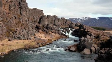 İzlanda 'da kaya oluşumlarını keşfeden turistler. Thingvellir Ulusal Parkı 'ndaki güzel kayalıklar ve derin yarıklar. Güney İzlanda.