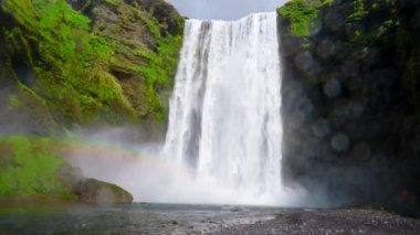 İzlanda 'nın görkemli doğası. Skogafoss şelalesine etkileyici bir manzara. Skogafoss, İzlanda 'nın en ünlü gökkuşağı olan yeri. Güzel 4k video.