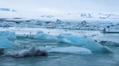 Buzdağlarının buzul gölünde yüzdüğü güzel bir manzara. Buzul oluşumlarının manzaralı görüntüsü. İzlanda 'daki Jokulsarlon buzullu gölünün Idyllic manzarası. Güzel İzlanda doğası.