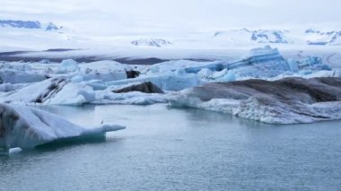 Buzdağlarının buzul gölünde yüzdüğü güzel bir manzara. Buzul oluşumlarının manzaralı görüntüsü. İzlanda 'daki Jokulsarlon buzullu gölünün Idyllic manzarası. Güzel İzlanda doğası.