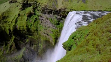 İzlanda 'nın görkemli doğası. Skogafoss şelalesine etkileyici bir manzara. Skogafoss, İzlanda 'nın en ünlü gökkuşağı olan yeri. Güzel 4k video.