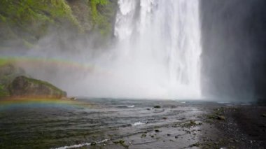İzlanda 'nın görkemli doğası. Skogafoss şelalesine etkileyici bir manzara. Skogafoss, İzlanda 'nın en ünlü gökkuşağı olan yeri. Güzel 4k video.