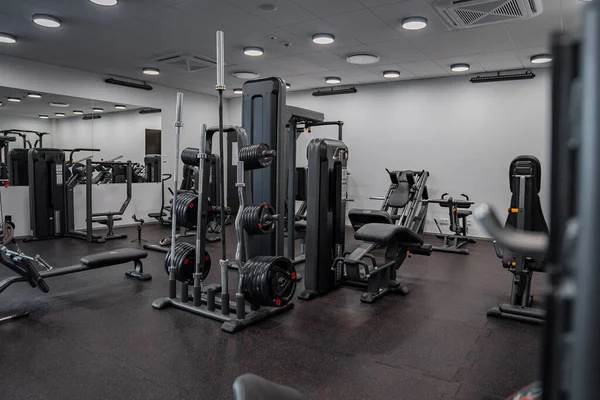 Modern light gym. Sports equipment in gym. Barbells of different weight on rack.