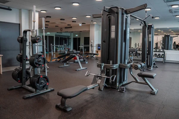 Modern light gym. Sports equipment in gym. Barbells of different weight on rack.