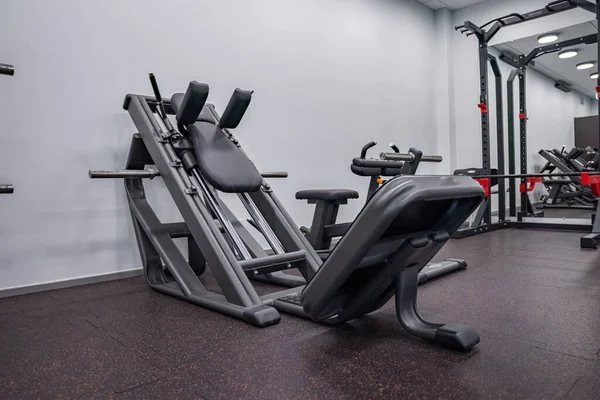 Modern light gym. Sports equipment in gym. Barbells of different weight on rack.