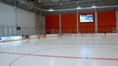 Empty hockey rink sport arena ice and light. People ice skating in a new hockey hall.