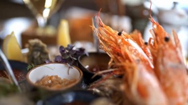 Fresh oysters on a plate with tiger prawns and other seafood. Top view of the sea food plate