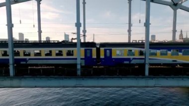 A bridge over river Daugava in Riga with a train passing by. Bridges in Latvia. Aerial Riga view.