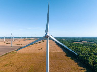 Panoramic aerial view of wind farm or wind park, with high wind turbines for generation electricity. Green energy concept.