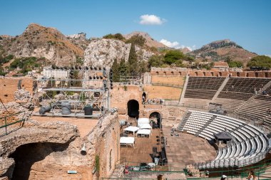 Antik İtalyan Tiyatrosu Antico di Taormina 'nın eski kalıntılarının panoramik manzarası. Taormina 'nın ünlü turistik merkezi. Güneşli bir günde Giardini Naxos Körfezi 'ndeki tarihi yapı..