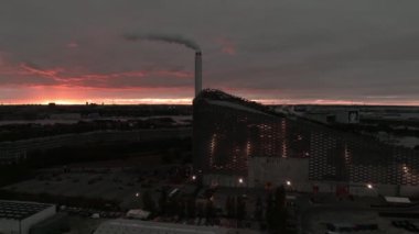 Amager Bakke 'nin hava görüntüsü, Copenhill Atık Enerji Santrali, gün batımında slaytlı ve şutlu yeşil kayak yamaçlı. Yeşil eko enerji santrali.