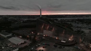 Amager Bakke 'nin hava görüntüsü, Copenhill Atık Enerji Santrali, gün batımında slaytlı ve şutlu yeşil kayak yamaçlı. Yeşil eko enerji santrali.