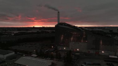 Amager Bakke 'nin hava görüntüsü, Copenhill Atık Enerji Santrali, gün batımında slaytlı ve şutlu yeşil kayak yamaçlı. Yeşil eko enerji santrali.