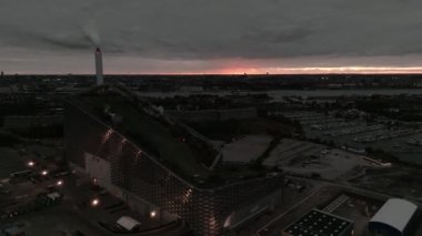 Amager Bakke 'nin hava görüntüsü, Copenhill Atık Enerji Santrali, gün batımında slaytlı ve şutlu yeşil kayak yamaçlı. Yeşil eko enerji santrali.