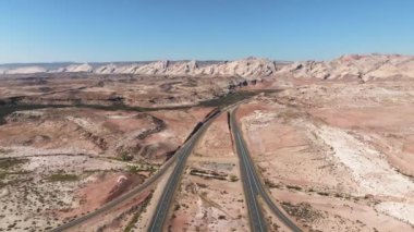 Kuzey Arizona otoyolu, kırmızı kayalar ve manzaranın içinden geçiyor. Hava 4K videosu. Anıt Vadisi yakınlarındaki Amerika 'ya güzel bir yolculuk..