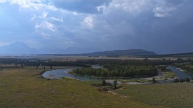 ABD 'nin Wyoming şehrinde bulutlarla dolu güzel bir yaz gününde Grand Teton Ulusal Parkı tepeleri, manzarası ve Yılan Nehri panoramik hava manzarası. Teton 'da büyülü doğa.