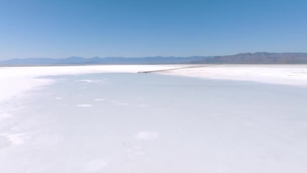 ソルトレイクシティユタ州ボンネビル塩フラットの空中ビュー Bonneville塩湖の上の青い空の美しい鏡の反射 地平線と自由のシーン — ストック動画