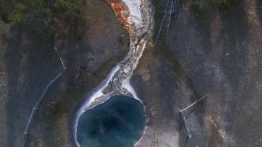 Yellowstone Ulusal Parkı 'ndaki koyu yeşil gayzer havuzunun havadan çekilmiş videosu. Yellowstone Ulusal Parkı 'ndaki renkli Norris Gayzer Havzası manzaralı