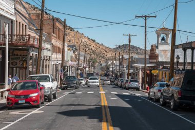 Virginia, ABD. Güneşli bir günde tarihi Virginia kovboy şehrindeki eski dükkanların arasında arabalar. Viktorya dönemi tarzı binalar ve elektrik sütunları arka planda açık mavi gökyüzü.
