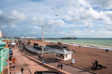 Brighton sahilinin yakınındaki gezinti alanında yürüyen insanlar. Deniz kıyısındaki tatil kasabası. İngiltere 'de Brighton havasının tadını çıkarıyorum..