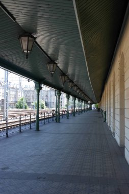 Seyahat beklentisi. Krakow tren istasyonu, eski boş tren platformu, eski fenerleri, metal kolonları, yeşil karizmatik çatılı ray hattı koridoru. Polonya