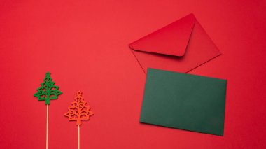 Noel ağacı oyuncağı, kırmızı ve yeşil zarflı şenlik arka planı. Kopyalama alanı ile şenlikli arkaplan.