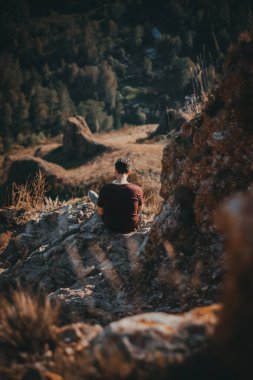 kayalıklarda oturan adam