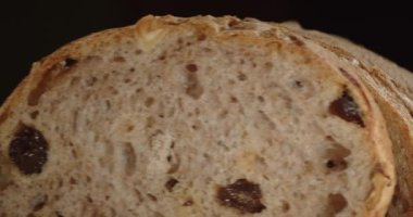 Kuru üzüm ve fındıklı bir somun taze ekmek. Kapat.