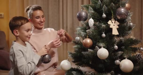 Mulher com criança se divertindo decorando árvore de Natal — Vídeo de Stock