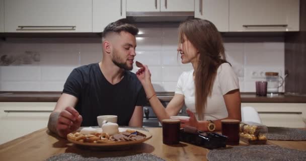 Girl and boy have fun at the table at home in the kitchen — Stock Video