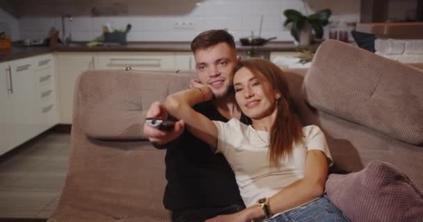 Закохана пара щасливо проводить час, дивлячись телевізор — стокове відео