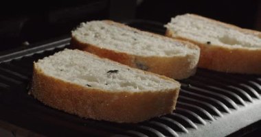 Taze kokulu ekmek dilimleri önceden ısıtılmış ızgaraya konur..