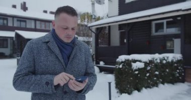Bir adam akıllı telefondan bir numarayı çevirir.
