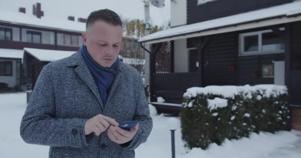 Мужчина набирает номер на смартфоне — стоковое видео