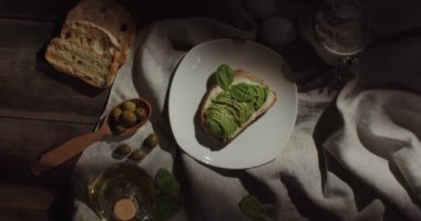 Avokado ve ıspanaklı iştah açıcı sandviç, ahşap bir masanın üzerine serilmiş.