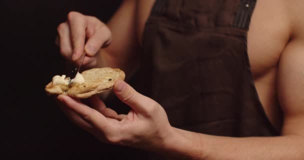 Joven sexy hombre seductor extiende mantequilla en el pan — Vídeos de Stock