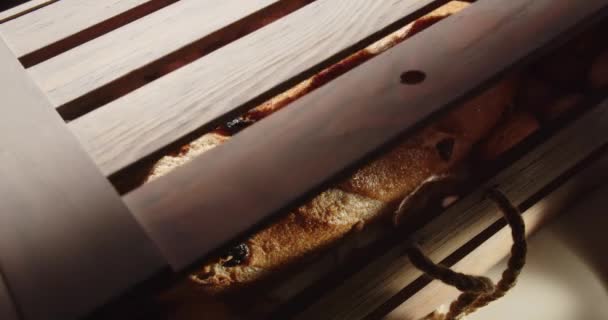 Otwórz drewniane pudełko z orzechami włoskimi i bochenek chleba z rodzynkami i orzechami w środku — Wideo stockowe