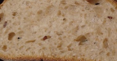 Keten tohumlu ekmek, dilimle. Siyah arkaplanda döndürme