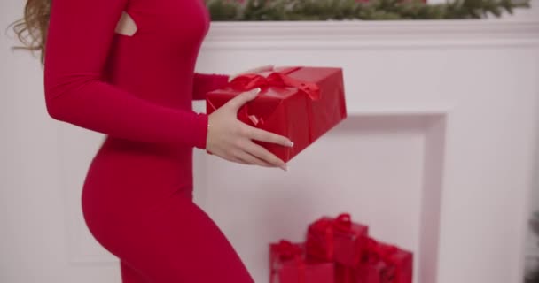 Mama legt mit roter Schachtel ein Geschenk unter den Weihnachtsbaum — Stockvideo