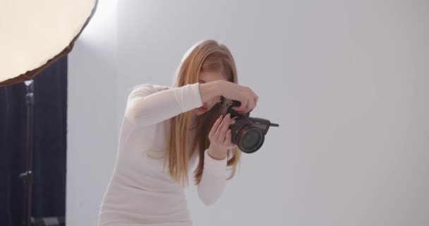 Fille photographe prend des photos dans le studio — Video