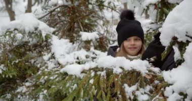 Karda saklambaç oynayan iki kız.