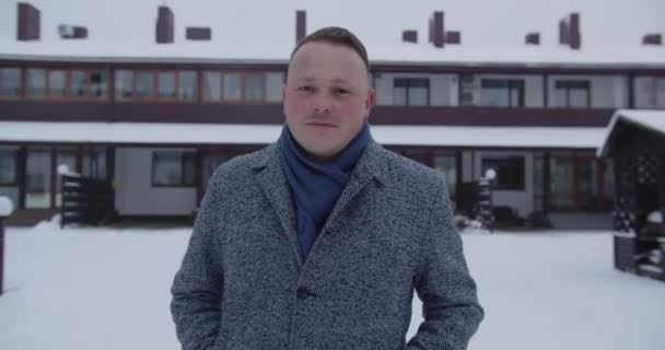 A man walks down the street in winter and smiles — Vídeo de Stock