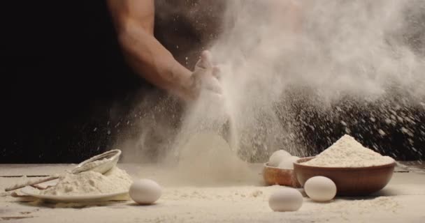 男は生地をこねて手で小麦粉を振る. — ストック動画