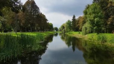 Birçok ağacın dikildiği ve nehrin aktığı eğlence parkı.