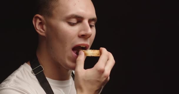Un jeune homme aime manger un morceau de pain frais fait maison — Video
