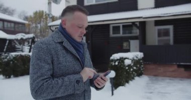 Bir adam akıllı telefondan bir numarayı çevirir.
