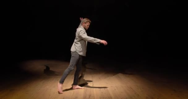 The guy is rehearsing a dance on stage learning the movements — Stock Video