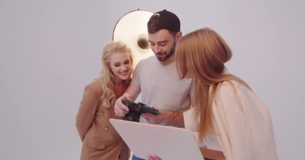 Stylist together with photographer and model choose successful shots photo shoot — Stock video